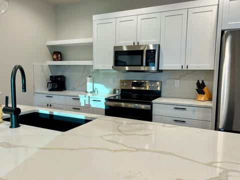 fully stocked spacious kitchen island with four inviting bar seats