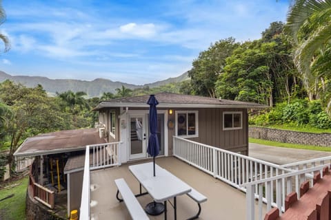A charming vacation home nestled in lush greenery, featuring a spacious outdoor deck.