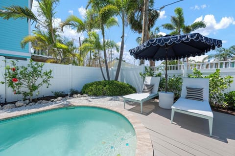 Heated pool with resort style loungers and umbrella