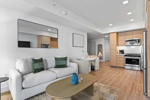 Modern downtown apartment with seating, kitchen, and smart TV.