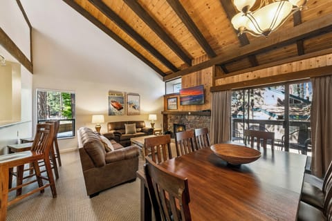 Unwind in your rustic mountain retreat with soaring wood-beamed ceilings, cozy stone fireplace, and forest views from every window.