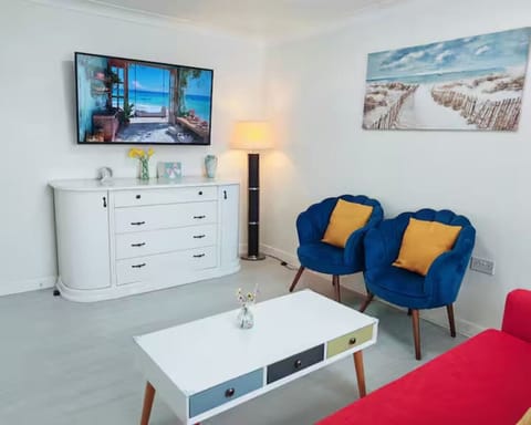 Bright and spacious living area with smart TV and comfy seating