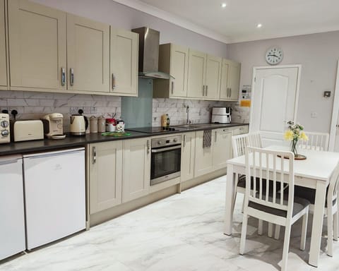 Prepare meals in the fitted kitchen with worktop appliances and cupboards.