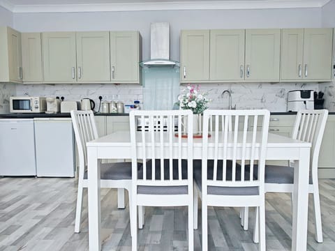 Fully equipped kitchen with a dining table in front of the cabinetry.