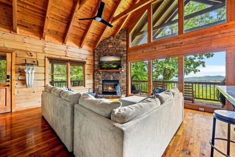 Vaulted ceilings, a crackling stone fireplace, and wall-to-wall views set the scene. Gather on the oversized sofa, unwind after a full day, and let the mountains do the rest.