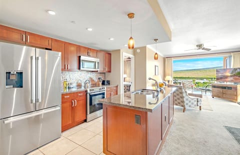 Sleek island kitchen flows into paradise views and cozy living space. HKK-820