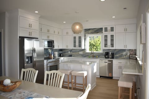 Coastal blue blacksplash and clean modern design with floor to ceiling cabinetry.