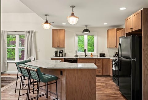 Whip up delicious meals in a fully stocked kitchen featuring a spacious island with high seating and top-of-the-line appliances—where cooking meets style and comfort.

