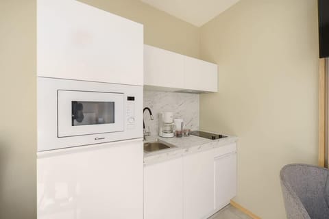 A close-up of a built-in microwave in a sleek, modern kitchen. The white countertops and minimalist design make the space feel fresh and clean.