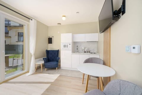 A different view of the same bedroom, showcasing the neatly made bed with soft white linens and a window providing ample daylight.