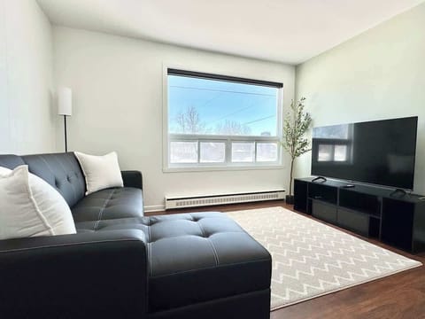 Profitez du confort de ce salon aéré où vous attendent un canapé d'angle en cuir confortable et une télévision à écran plat.