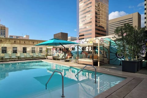 Rooftop pool with lounge chairs, cabanas, and colorful mural backdrop