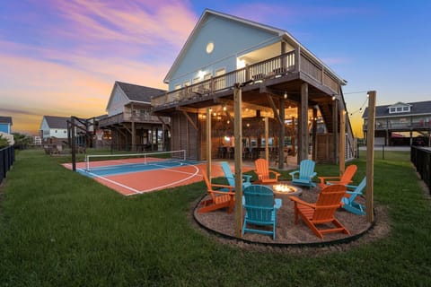 Private pickleball court, covered tiki lounge, and firepit in one backyard setup.