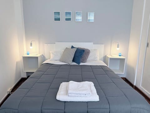 Dormitorio luminoso de estilo moderno, cama doble, textiles neutros y detalles minimalistas.