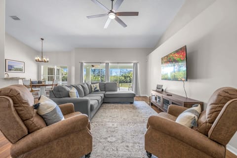 Spacious living room with comfortable seating and natural light from large windows.