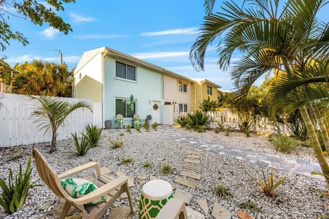 Relax in the cozy outdoor seating area surrounded by tropical landscaping.