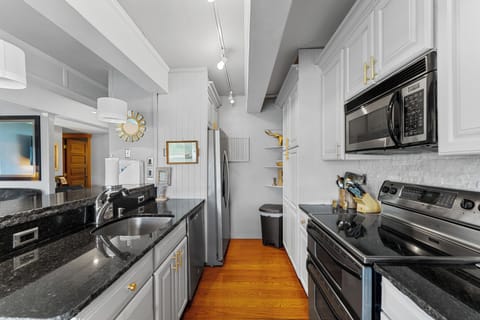 Full kitchen featuring upgraded countertops, stainless steel appliances, and breakfast bar seating 2.
