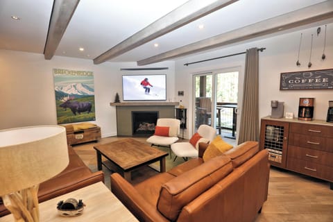 Living room featuring a warm gas fireplace and a built-in coffee bar. 