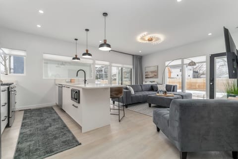 The open layout connects the kitchen and living room, creating a bright and welcoming space where everyone can gather, prepare meals, watch TV, and spend quality time together.