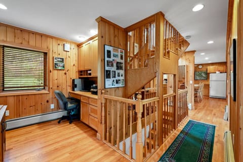 Dedicated home office with built-in desk, wood paneling, and plenty of natural light.