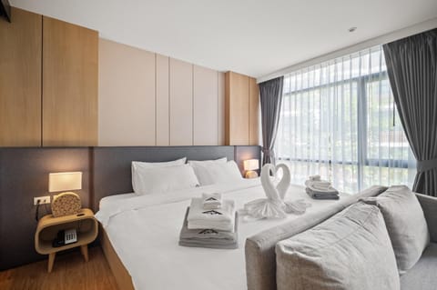 Queen-size bedroom with branded linens and decorative towel setup.