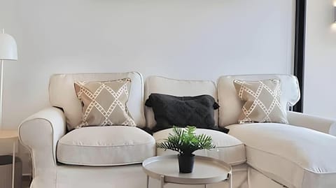 Comfortable lounge corner w/ plush seating, neutral tones & a small coffee table