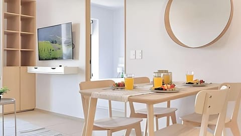 Cozy dining nook w/ round mirror, warm wood table & a clean modern look