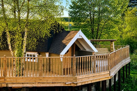 Flora Cabin is a cozy countryside retreat with a charming wooden exterior, surrounded by peaceful greenery and fresh air. Its warm, rustic design offers the perfect escape for relaxing stays, quiet mornings, and nature-filled getaways.
