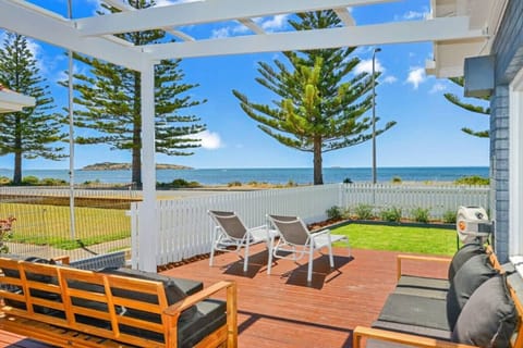 Step out to a sunlit deck where ocean views set the scene, with lounge seating and deck chairs inviting you to unwind, soak up the sea breeze, and settle into slow coastal moments.