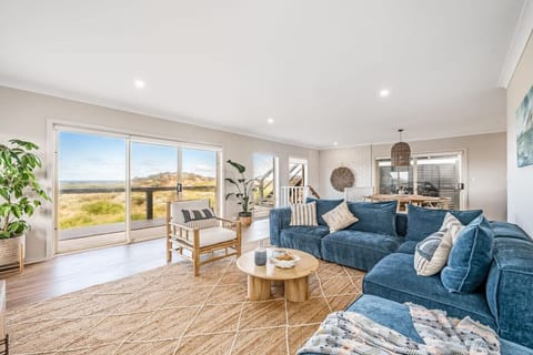 Relax in the sun-filled open plan living area, where plush seating, natural textures, and sweeping views create the perfect setting for downtime or entertaining.