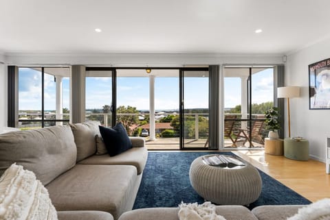 Relax in the sunlit lounge where floor-to-ceiling windows frame sweeping views and open to the balcony for breezy afternoons.