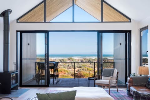 Settle into the main living space as ocean views stretch beyond the windows and anchor the room to its coastal setting.