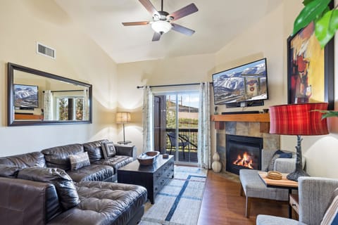 - Living room with leather sectional and cozy fireplace  
- Flat screen TV with balcony access and mountain views  
- Perfect for gathering after a day of outdoor adventures