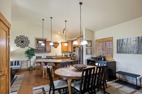 - Open concept kitchen with granite counters and wood cabinets  
- Dining table with seating for six under pendant lighting  
- Spacious layout blends cooking and gathering together