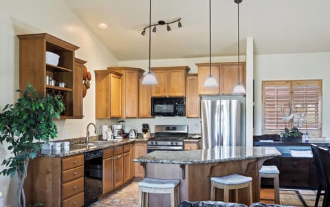 - Spacious kitchen with granite countertops and warm wood cabinets  
- Stainless steel appliances and pendant lighting add style  
- Island with barstools perfect for casual meals or gathering
