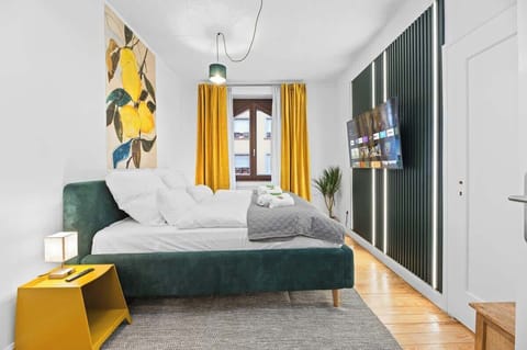 Das Schlafzimmer mit großem Bett und moderner TV-Wand.