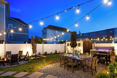 Private backyard oasis, beautifully illuminated by overhead string lights