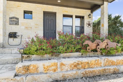 Welcome to 'Timbuktu Hotel' Suite #2! This charming entrance is adorned with vibrant red flowers, rustic horse-themed decor, and welcoming Texas star accents, setting the perfect tone for your stay.