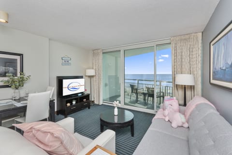 Living room with balcony and ocean views, perfect for relaxing stays