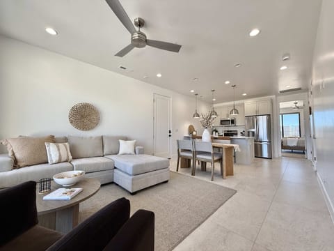 The living room, dining area, and kitchen blend seemlessly in this open concept floor plan