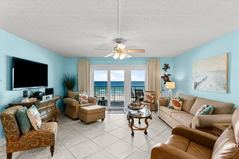 Bright living room w/ ceiling fan, ocean view, & comfortable seating for the whole group.
