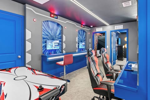 Experience a vibrant gaming paradise with sleek blue walls and modern decor. Enjoy high-tech gaming stations, comfy seating, and a stylish air hockey table, all perfect for friendly competitions and endless fun.