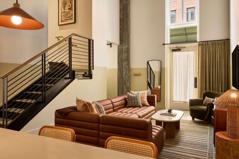Living area with sofa near stairs and bright windows