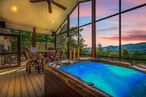 Unwind in the bubbling hot tub as the sun sets over the Smoky Mountains, all from the comfort of a private, screened-in porch with panoramic views and cozy seating.