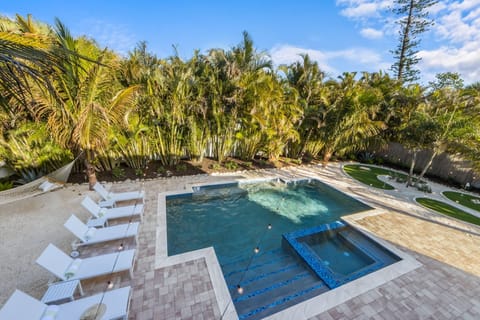 Backyard view from the covered porch off the kitchen--pool, golf, loungers.