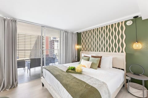 Modern bedroom with balcony access, artistic wall, and serene views