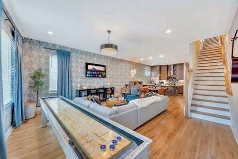 Hardwood floors throughout the open living area keep the pace light and fast, sectional sofa, shuffleboard table, and TV all in sight lines