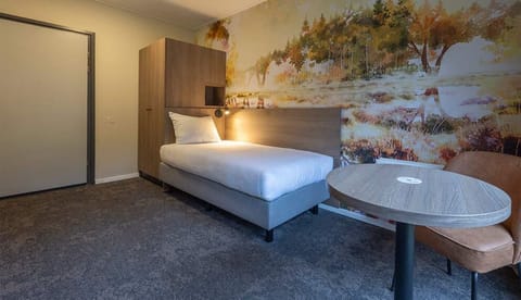 Unwind in crisp bedding beside a calming nature mural.