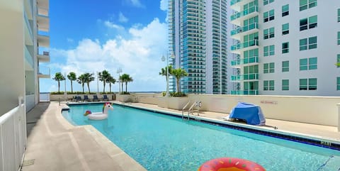 A sleek, modern rooftop pool glistens under the sun,