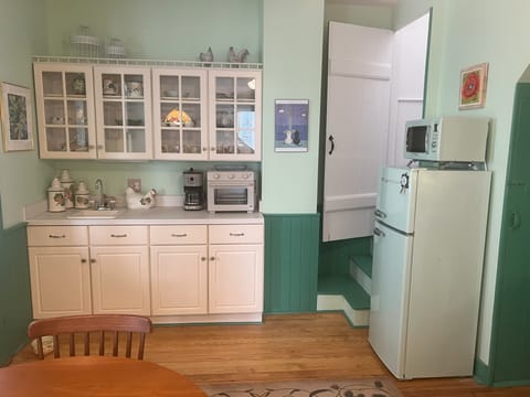 The kitchen includes a small fridge, microwave, coffee maker, and toaster oven